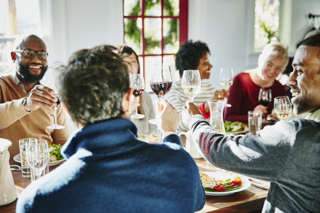Smiling group of friends toasting during holiday meal together