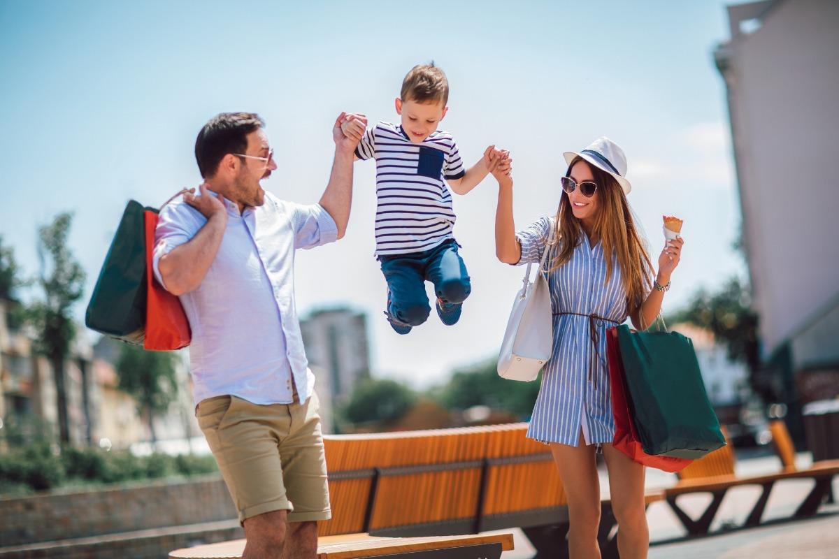 A picture of a father, mother, and son shopping at a local shopping center.