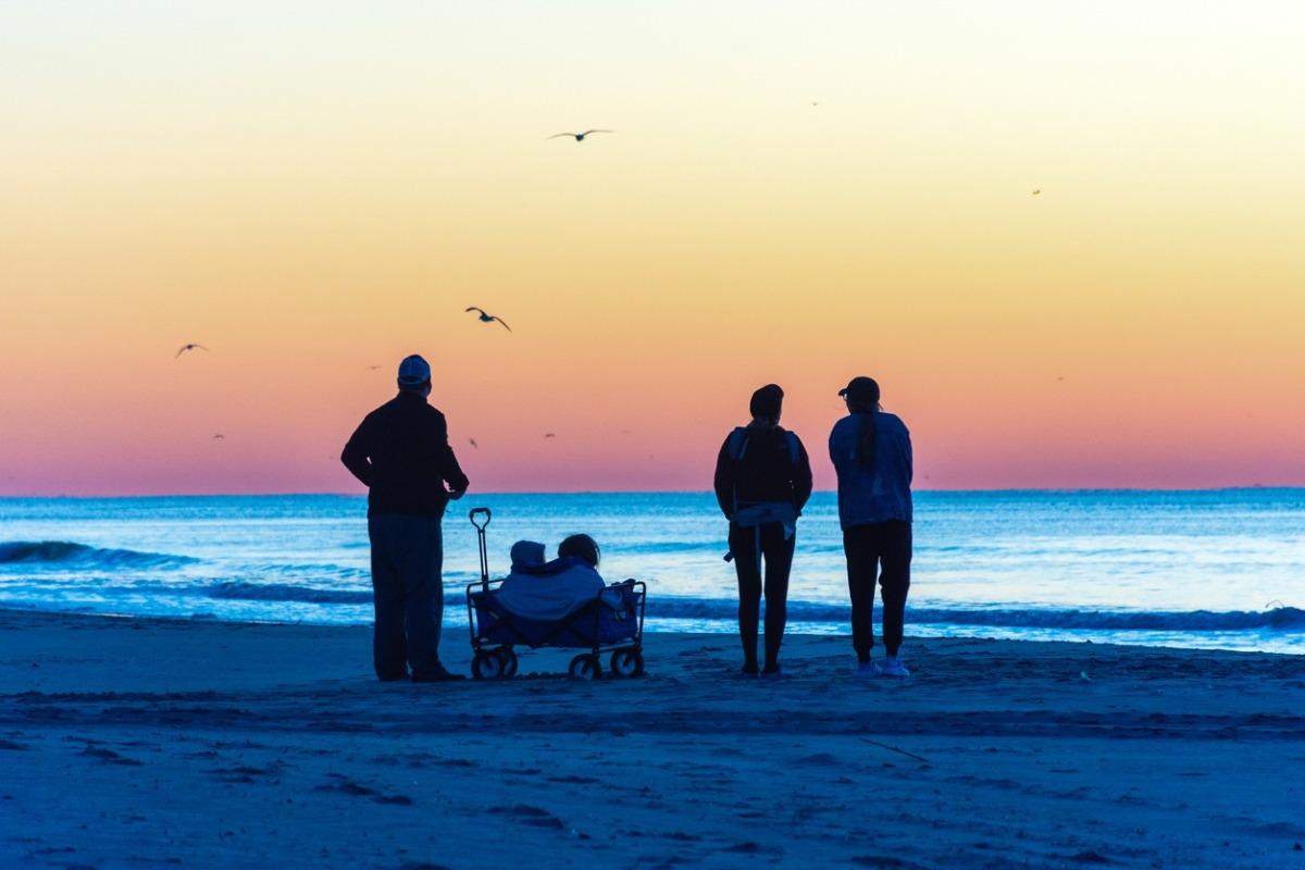 A family watching the sunrise on the beach in the Windy Hill section of North Myrtle Beach.